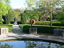 Ornamental garden with stone blocks with incised lettering around the edge of a pond