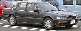  Front three-quarter view of a four-door car with a three-box body style.