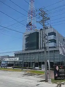 Corporate Guarantee and Insurance Company building, the headquarters of CLTV 36, a four-story modern office building with a tall red and white antenna behind a BMW dealership, on Jose Abad Santos Avenue in San Fernando, Pampanga, April 2017