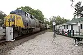 Freight train passing a small building