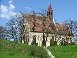 A stone church with a small tower on a hill