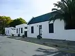 Group of restored Karoo-type cottages in Bourke and Parliament Streets. Karoo-type with finely moulded broken pediment parapets and heavy cornices. Walls have corner mouldings and plain architraves at doors and windows. Stoeps. 4 panel doors with uppe Architectural style: Karoo-type. Current use: Self-catering tourist accommodation. These buildings, with their Georgian Karoo style and Victorian characteristics and which date mainly from the nineteenth century, form an integral part of the historical and architectural core of Graaff-Reinet, which was founded in 1785.