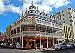 The Blue Lodge Hotel consists of a treble-storeyed building with two balconies and a steep roof with dormer windows, pinnacled gables and a corner turret of exuberant late-victorian design, just before 1900. The balconies have intricate moulded MacFarlane This impressive late Victorian building, which was erected at the turn of the century, forms an integral part of the architectural character of Long Street, a part of Cape Town where a uniformity of character has to a large extent remained. Architectural style: VICTORIAN. Type of site: Commercial. This impressive late Victorian building, which was erected at the turn of the century, forms an integral part of the architectural character of Long Street, a part of Cape Town where a uniformity of character has to a large extent remained.