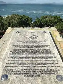 Plaque with writing on it overlooking the sea.