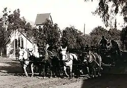 Central Ave, Sierra Madre, CA in 1905. A mule team is grading the Ave for the installation of the 1906 Pacific Electric street car, in the background is the Old North Church with the original barn roof bell tower.