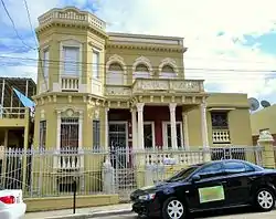 Photograph of an ornate two-story townhouse with an octagonal corner tower