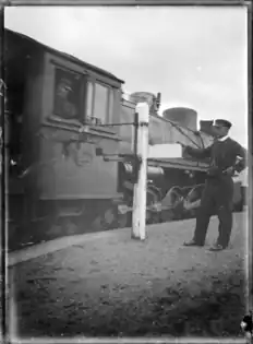 Changing the tablet at Horopito Railway Station, with an X class in 1920.