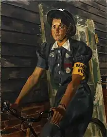 A girl in ARP uniform, wearing a tin helmet and riding a bike