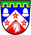 a chief enhanced—Per chevron Azure and Gules on a chevron between in chief two acorns and in base a unicorn's head erased all Argent three mullets Gules pierced a chief enhanced and embattled Vert fimbriated Or. — Matthews, Scotland