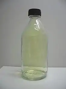 A translucent pale yellow gas in a sealed bottle