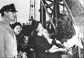 Irene Dunne and Louis B. Mayer christen SS Carole Lombard while Clark Gable and Mrs. Walter Lang, who was Lombard's secretary, observe.