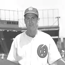 A man in a light baseball jersey with a dark "O" on the left breast and a dark cap with a light "O" on the center