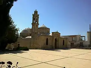 Stone church with domes and a spire.