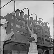 Closing of the Jerome Relocation Center, Denson, Arkansas. A teacher in the Jerome school bids goodye to some of her little pupils as they wait in the trucks to be put on the trains to other centers.