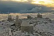 La Silla Observatory blanketed in snow as the Sun sets.