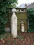 Coal Duty Boundary Marker (in the fence to the back of the garden of Number 57 Baldwyn's Park) and adjacent iron bollard