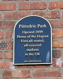 A black plaque with the text " Pittodrie Park Opened 1899 Home of the Dugout First all-seated, all -covered stadium in the UK. AFC Heritage