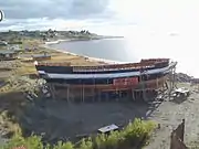 Completed hull of the 1:1 replica of HMS Beagle being painted in Nao Victoria Museum in Punta Arenas