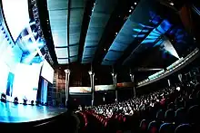 A photograph of CCM's Corbett Auditorium with audiences watching projections displaying on the stage.