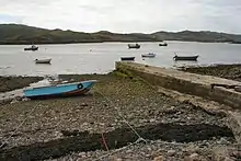 Photograph of the the Culkein Drumbeg jetty and several small boats in the water