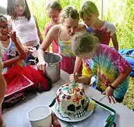 Cutting a Calavera shaped birthday cake