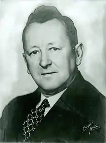 Portrait of Caucasian man with black hair, wearing a suit