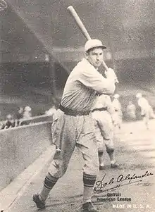 A man wearing a baseball cap and jersey posed prior to swinging his baseball bat