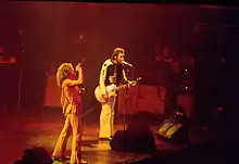 Roger Daltrey singing and Pete Townshend singing and playing a guitar