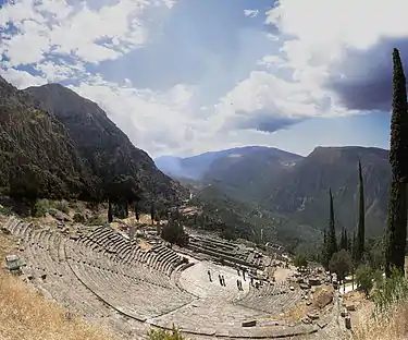 Ruins of an amphitheatre in a mountain landscape.