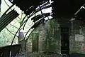 Derelict Nissen hut interior; the corrugated iron sheets forming the walls and roof are supported by brick partition walls and metal girders