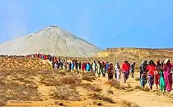 Pilgrims heading to a volcano in an arid landscape