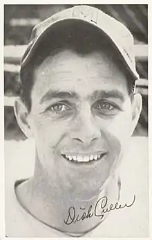 A man win a light baseball uniform and dark cap with an "M" on the center.