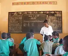 Students working in groups in classroom as teacher observes