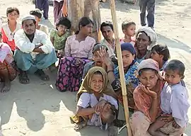 people, mostly children, squatting on the ground