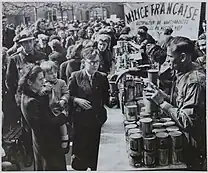 Black and white photo showing distribution of preserves to women and children