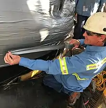 Industrial adhesive applied by a maintenance professional demonstrating safe application during an emergency repair scenario