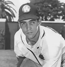 A man in a light baseball jersey and dark cap with "LA" on the center