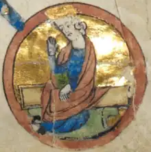 A circular medieval miniature, showing a man in blue robes, with long flowing hair and a short beard.