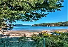 Eggs and Bacon Bay beach path to sandy beach with row boats to one side