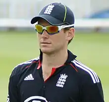  A man wearing an England cricket shirt, a cap and sunglasses