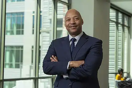 Portrait of Erick Jones in a blue suit.