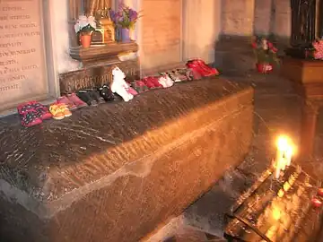 St Erkemboden's tomb in Saint-Omer Cathedral, with votive offerings placed on top.