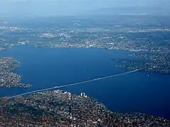 A long floating bridge crossing a lake in a suburban area