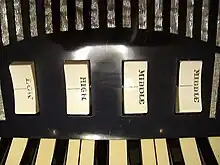 Set of two-way rocker switches (labeled LOW, HIGH, MIDDLE, MIDDLE) controlling individual reed ranks for the treble keyboard of an Excelsior accordion.