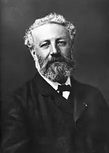 A white bearded man with grey hair dressed in 19th-century clothes