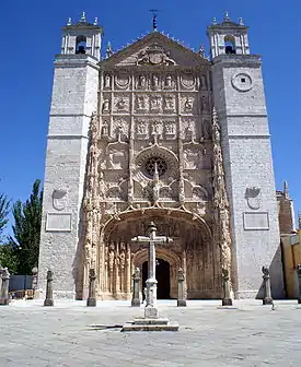 A tall stone building, topped with a cross.