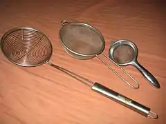 Several wire meshes shaped like bowls, with metal handles.