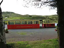 Fintown Railway on trackbed of CDR County Donegal Railways Joint Committee, next to Lough Finn with a train in the platform at Fintown station.