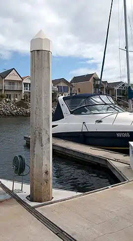 A floating dock at a private marina.  The vertical "spud" only anchors the dock sections in place, and does not provide structural support for loads upon the dock.