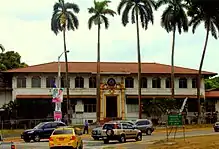 Former YMCA building in Panama Canal Zone, a gold and white building, now fenced off from the public.